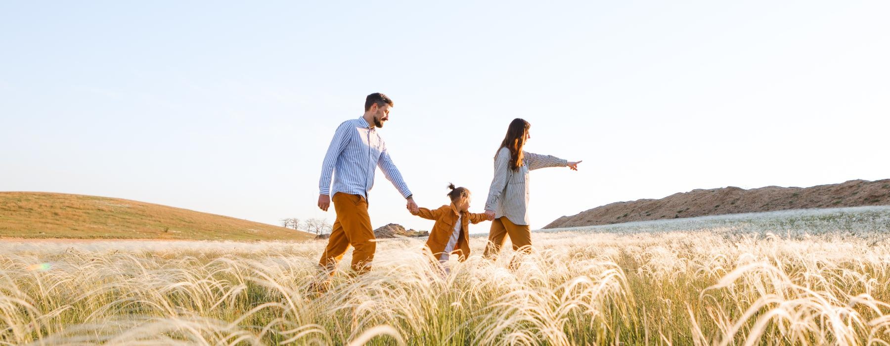 a family walking through a field of wheat