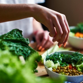 a person putting a salad in a bowl